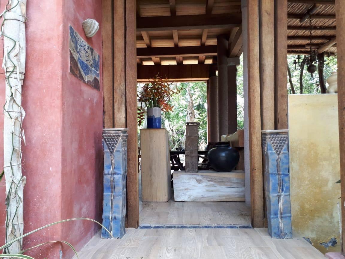 Portal de acceso con muros de color y columnas de cerámica.